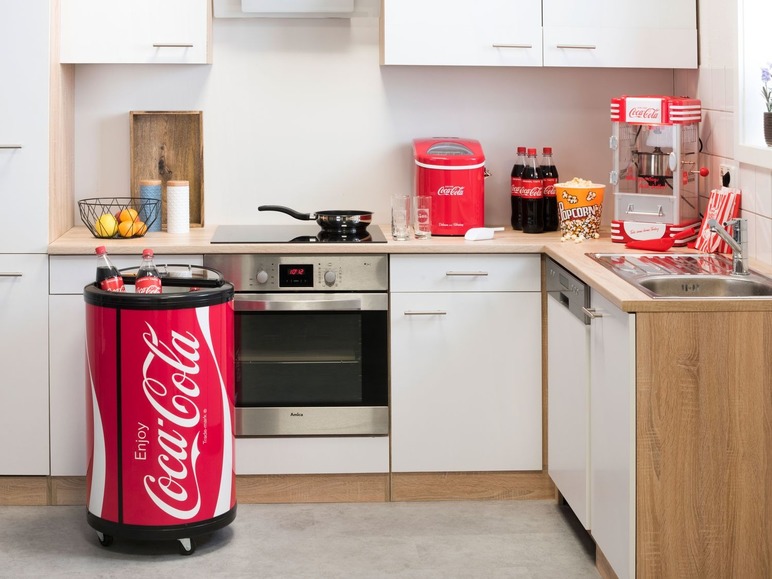 Een Coca-Cola koelbox in een keuken met een popcornmachine.