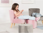 Een roze fluwelen fauteuil voor kinderen met bijpassende poef.