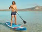 Man paddling on a blue and red inflatable sup board, with a black paddle