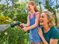 Een moeder en dochter lachen terwijl ze met een tuinslang in de tuin spelen.