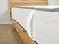Een wit matras met een houten frame.