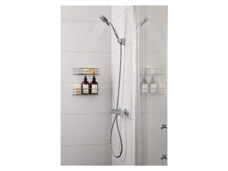 Douche met handdouche, doucherek met flessen en sponzen in een wit betegelde badkamer.