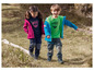 Twee kinderen dragen outdoor kleding van McKinley, waaronder een roze jas en een blauwe jas.