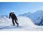 Vrouwelijke snowboarder met helm en skibril daalt af van besneeuwde bergen.