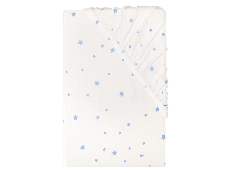 Wit hoeslaken voor baby met blauw sterrenpatroon.