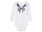 Witte baby romper met lange mouwen en een zwarte strik.
