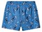Blauwe pyjamashort met cartoonfiguren en maan-sterrenmotief.