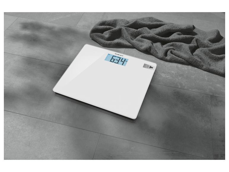 Witte SilverCrest weegschaal met digitaal display en handdoek.