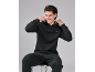 Man in zwarte hoodie en joggingbroek, zittend op een kruk.