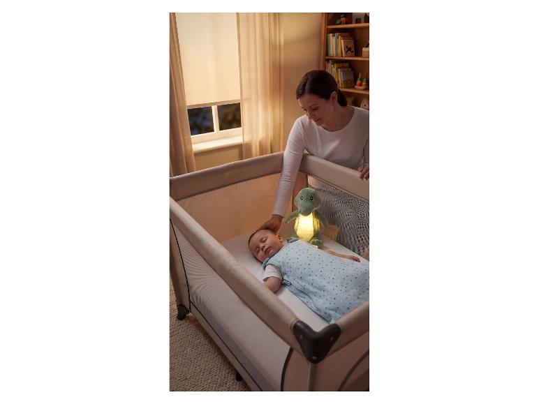 Moeder legt baby in reiswieg met lichtgevend knuffeldier.
