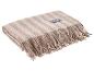 Beige plaid met visgraatpatroon en franjes, met een zwart etiket.