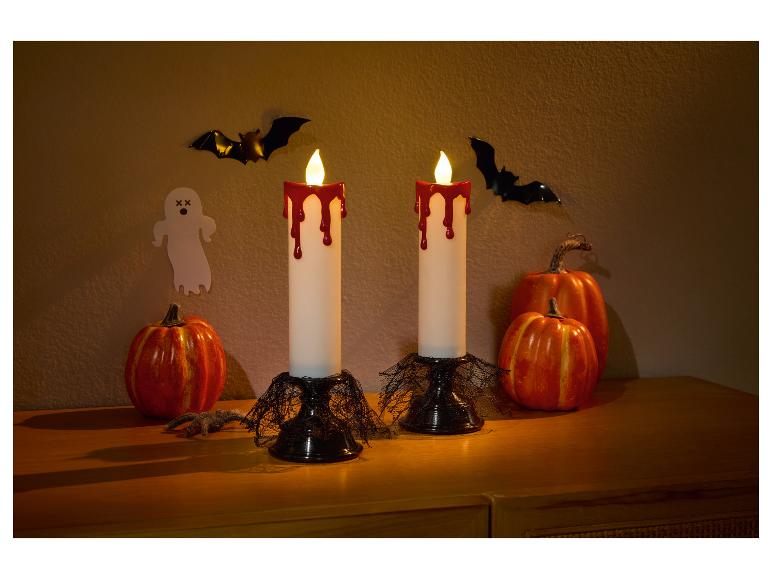 Halloween decoratie met twee bloedende kaarsen, pompoenen, vleermuizen en een spookje.