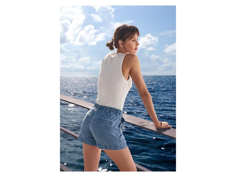 Vrouw in ESMARA® jeansshort op een boot met uitzicht op zee.