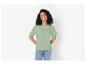 Een vrouw draagt een groene T-shirt en blauwe jeans.