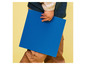 Een kind dat een grote blauwe LEGO-basisplaat vasthoudt.