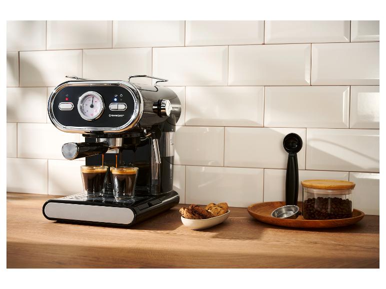 Zwart espressomachine zet twee koffies, met koekjes en koffiebonen.