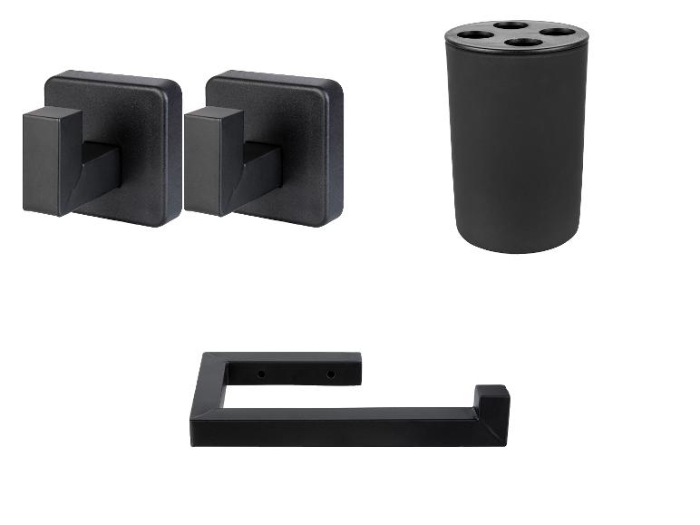 Zwarte badkameraccessoires: twee haken, een beker en een toiletrolhouder.