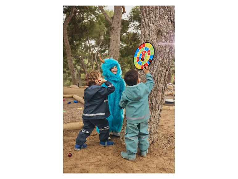 Drie kinderen spelen darts in een park.