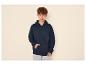 Jonge man in een donkerblauwe hoodie en lichtblauwe jeans.