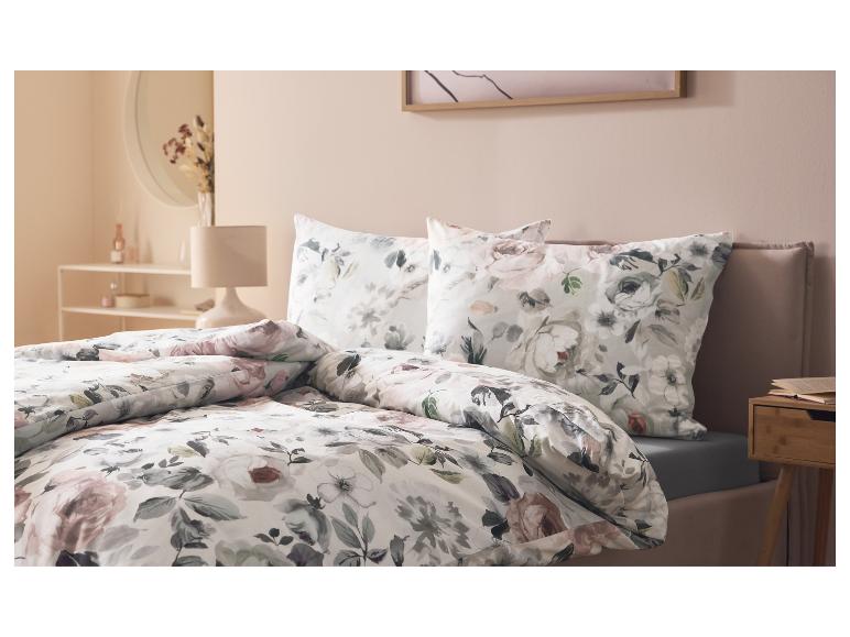 LIVARNO home jersey hoeslaken op een bed met bloemig beddengoed