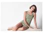 Model draagt een olijfgroene tanktop en gestreepte shorts.