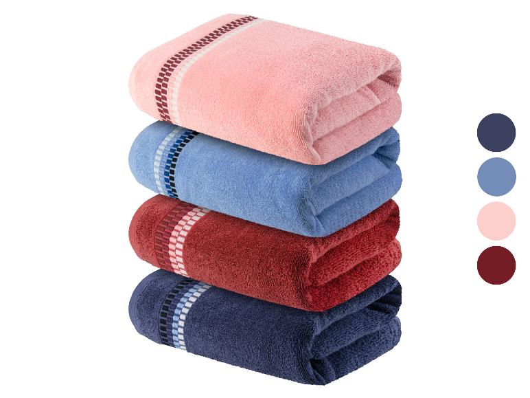 Een stapel badhanddoeken in roze, blauw, rood en donkerblauw.