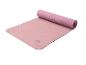 Roze Crivit yogamat, gedeeltelijk opgerold, met antislip textuur.