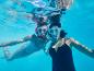 Twee vrouwen in badkleding snorkelen onderwater.