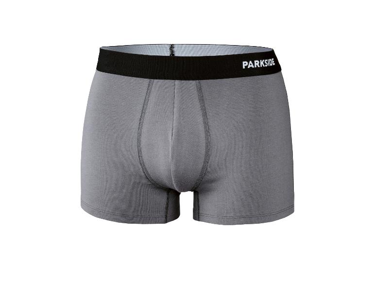 Grijze boxershort met zwarte elastische tailleband en witte tekst.