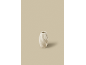 Witte keramische vaas met golvende textuur op een beige achtergrond.