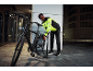 Man in reflecterende jas pompt fietsband op in de nacht