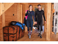 Paar in ski-thermokleding, met helmen en ski's op de achtergrond.