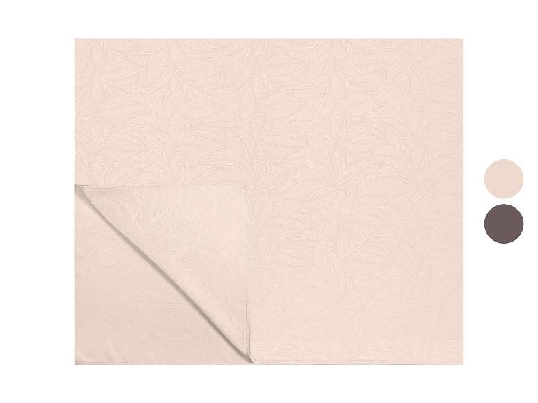 Beige tafelkleed met bladpatroon, met een gevouwen hoek.