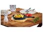 Gietijzeren pan met gebakken aardappelen, zout, tomaten en rozemarijn op een houten tafel.