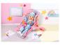 BABY born pop in een roze autostoel, met blauwe outfit en muts, omringd door sterren.
