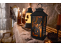 Halloween lantaarn met 'Happy Halloween' tekst, kaarsen en griezelige decoraties.