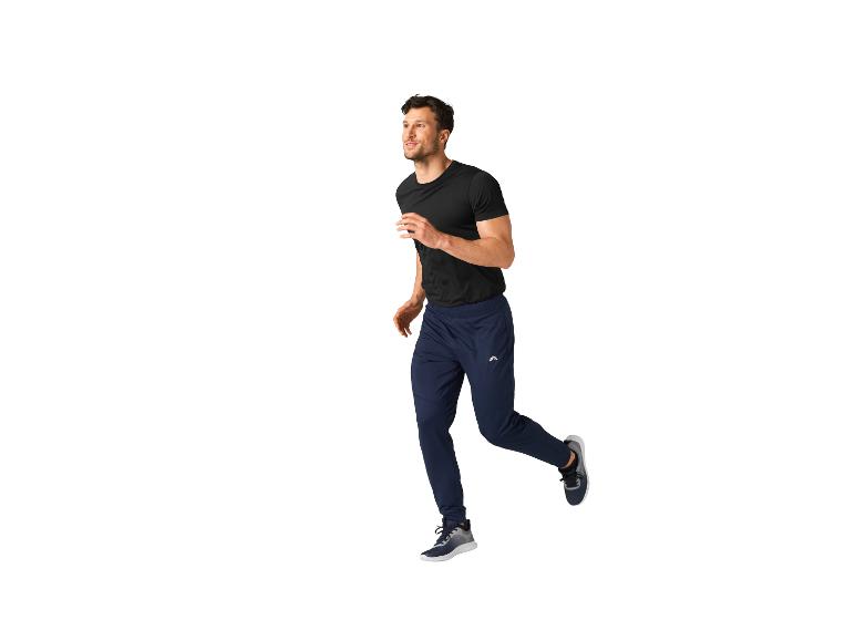 Man in joggingbroek en zwart T-shirt, rennend.