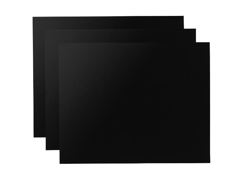 Drie zwarte vellen papier op elkaar gestapeld.