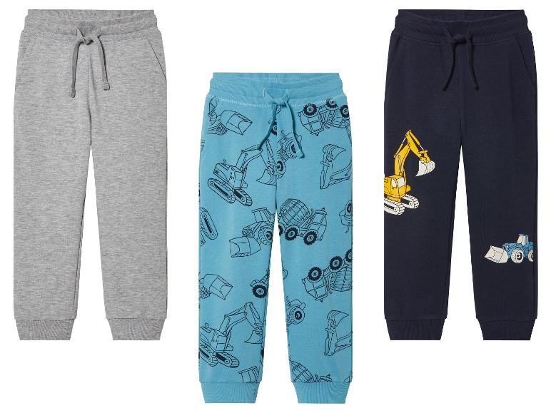 Drie jongensjoggingbroeken met graafmachines en andere voertuigen.