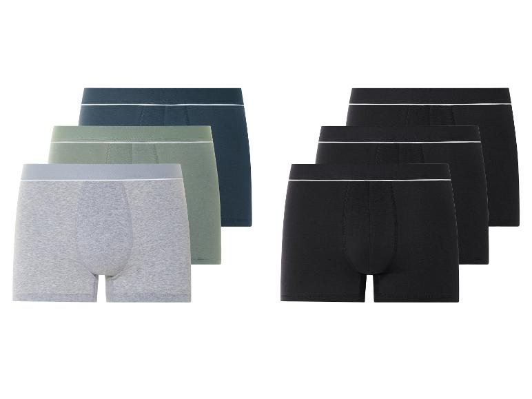 Drie paar boxershorts in verschillende kleuren.