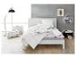 Moderne slaapkamer met wit bed, Balette dekbed en kussens, vloerlamp en wandplank.