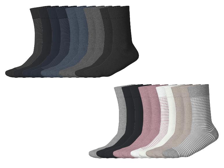 Twee sets sokken, één in donkere effen kleuren en strepen, de andere in lichte effen kleuren en strepen.