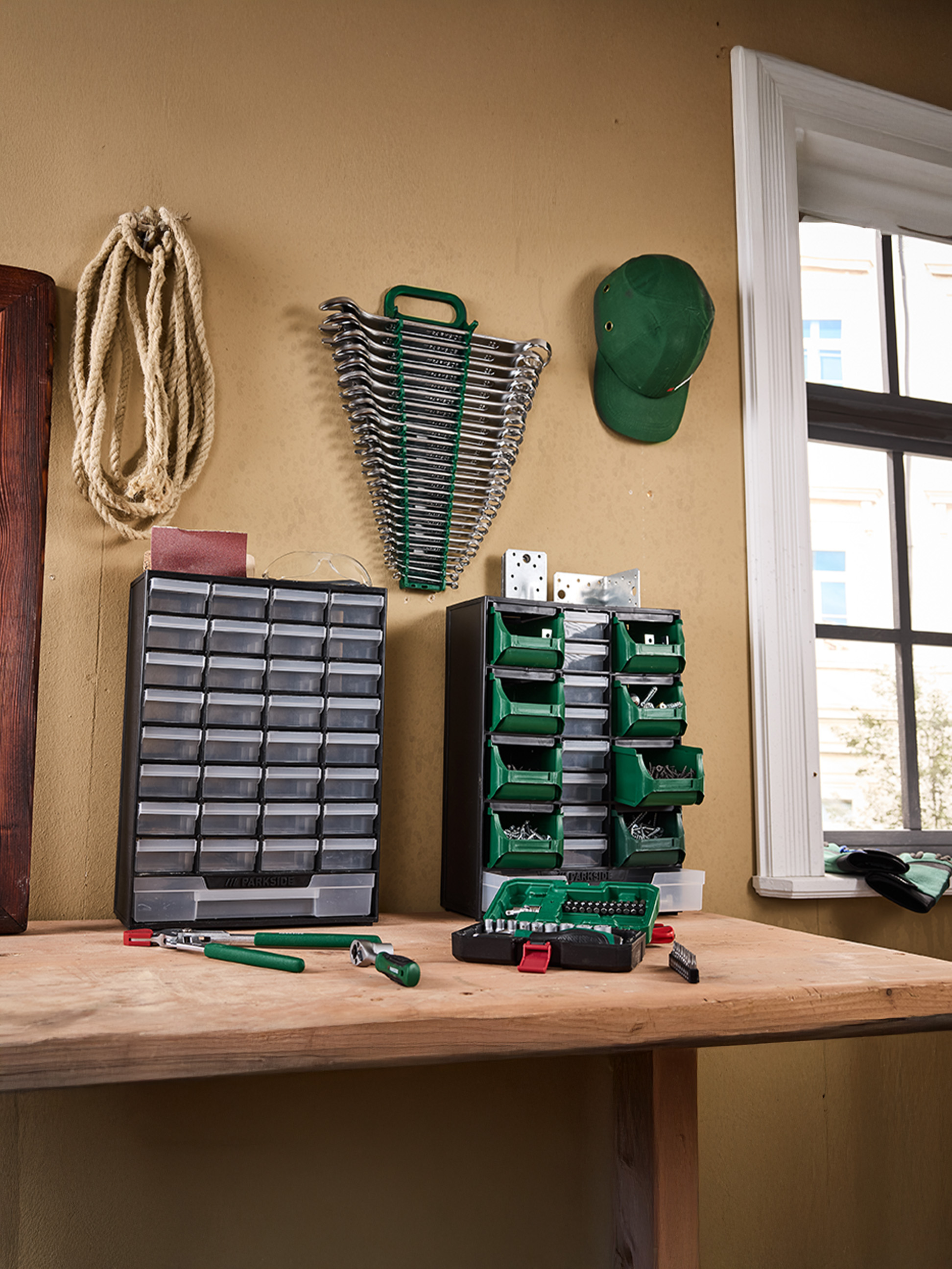 PARKside gereedschap en organizers op een werkbank, inclusief moersleutels, schroeven en bits.