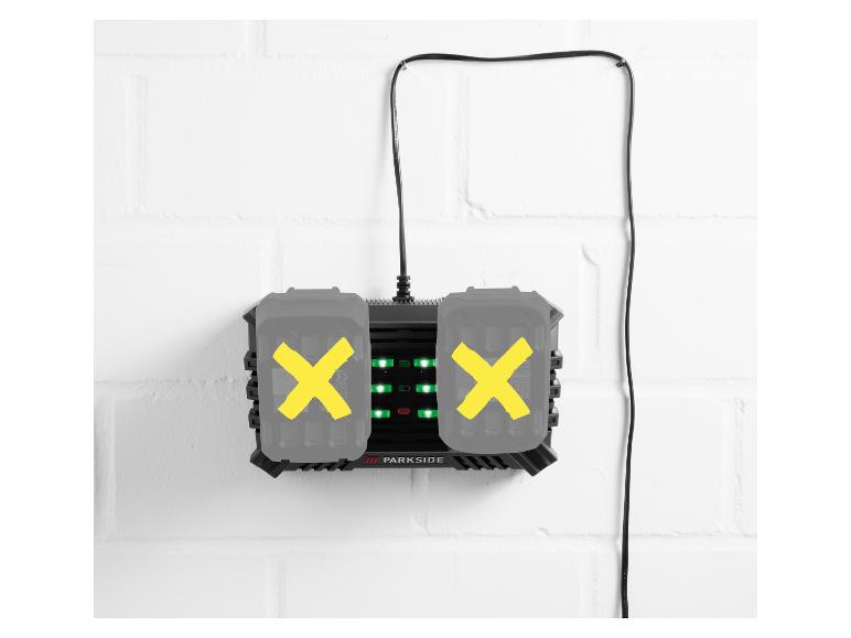 PARKSIDE dubbele acculader met twee accu's aan een witte bakstenen muur.
