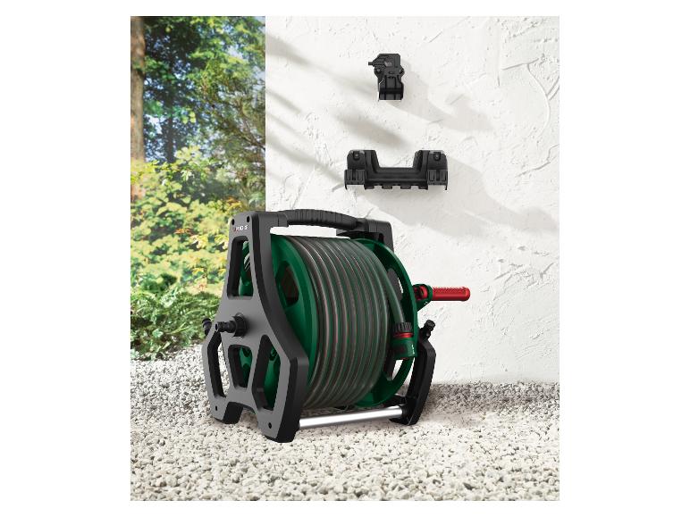 Parkside tuinslangwagen met slang en muurbeugels op een grindondergrond.