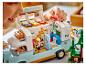 Een kind speelt met een LEGO Friends set, een gedetailleerde camper met figuren.