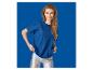 Vrouw in een blauw T-shirt en zilveren legging, lachend, tegen een blauwe achtergrond.