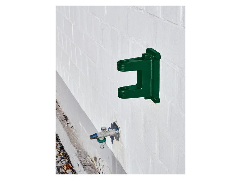 Groene muurbeugel voor tuinslang met een kraan eronder.