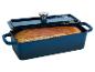 Blauwe gietijzeren broodvorm met een goudbruin brood, met deksel erop.