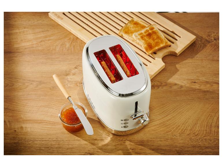 Witte retro broodrooster met geroosterd brood en jam.